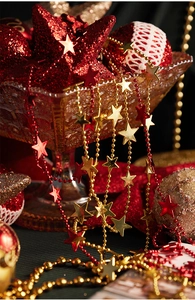 Detail of red and gold Christmas star garland with beaded chains and glitter ornaments