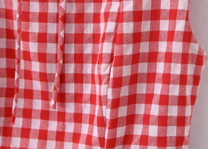 Détail du tissu à carreaux rouges et blancs avec des cordons de serrage décoratifs