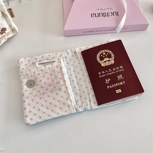 Detail view of pink polka dot fabric passport holder with internal card slots and snap button