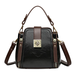 Black and brown contrast bucket bag with gold square buckle and adjustable strap