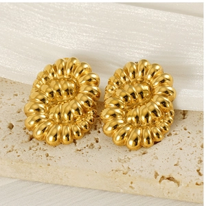 Détail de boucles d'oreilles torsadées en acier doré 18 carats avec texture côtelée