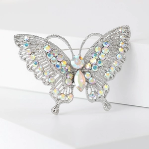Detailed macro of vintage butterfly brooch with rainbow AB rhinestones on white steps