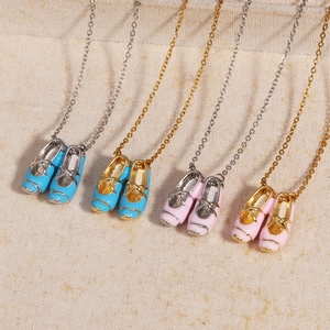 Detailed display of ballet slipper pendant necklaces in pink and blue on golden chains