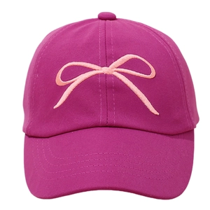 Detailed view of a vibrant magenta kids baseball cap with a light pink embroidered bow