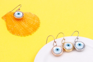 Detailed view of Evil Eye hook earrings in gold, silver, and rose gold finishes