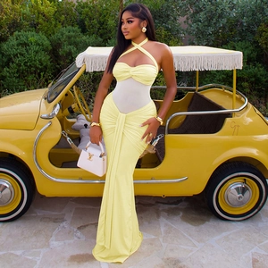Detail of yellow halter maxi dress featuring sheer white mesh waist panel and mermaid hem