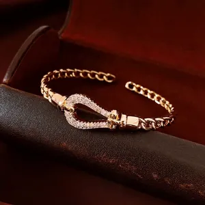 18K gold-plated teardrop horseshoe buckle bracelet with pave-set crystals on luxury curb chain