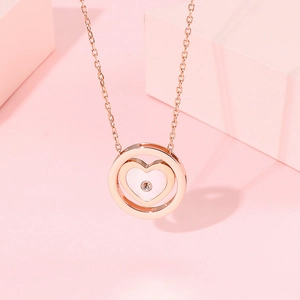 Vue macro d'un pendentif coeur en or rose avec cercle et détail en zircon brillant