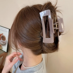 Detail view of a square dusty purple hair claw clip used for a neat bun hairstyle