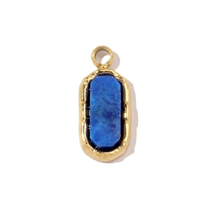 Détail d'un pendentif ovale en acier titane doré orné d'une pierre de lapis-lazuli