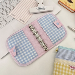 Detailed view of pink quilted fabric three-ring binder with blue checkered border