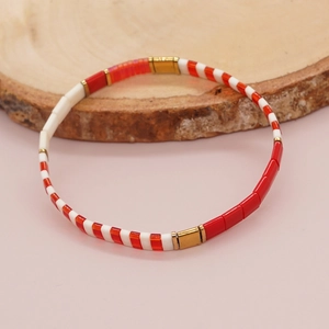 Bohemian Tila bead stretch bracelet with red and white tiles on a wooden display