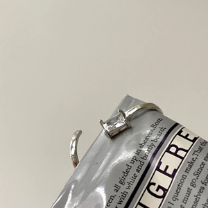 Macro view of adjustable silver ring with rectangular zircon in four-prong setting
