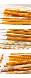 Detail of stacked tile bracelets featuring bright orange and cream enamel on gold metal
