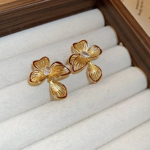 Macro shot of gold floral earrings with water-drop cubic zirconia in jewelry box
