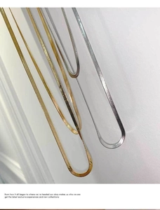 Detailed close-up of flat snake bone necklaces in gold and silver stainless steel