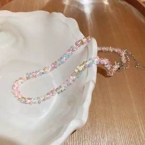 Détail d'un collier de perles colorées avec cœurs dans un plateau en céramique