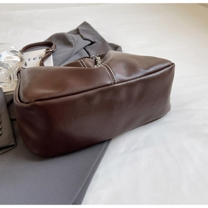 Close-up of brown PU leather shoulder bag featuring decorative white contrast stitching