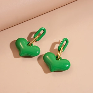 Detail view of vibrant green heart charms with gold-tone U-shaped earrings and smooth finish