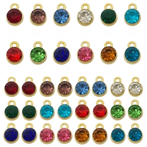 Detailed view of 12 multi-colored round birthstone charms with gold alloy settings for DIY