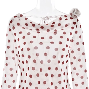 Polka dot chiffon dress featuring a draped neckline and floral shoulder detail