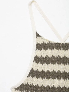 Dettaglio del tessuto a maglia ondulata beige e oliva con fili metallici dorati