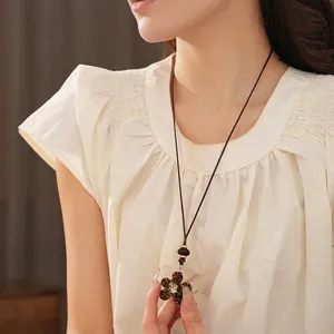 Collier rétro avec pendentif fleur en résine motif léopard et perles sur un pull
