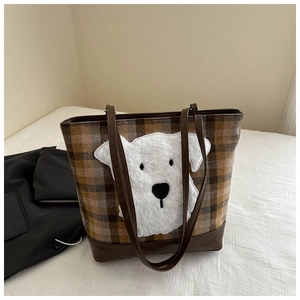 Detail of checkered tote bag featuring a cute white plush dog patch and brown faux leather