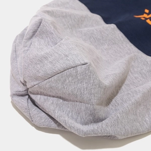 Detailed close-up of grey and navy knit fabric with orange printed letter design