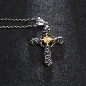 Macro shot of silver punk cross pendant with gold star detailing and textured relief