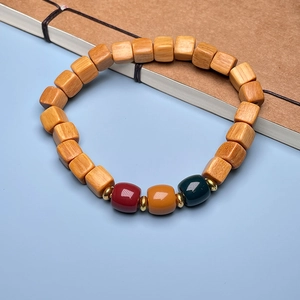 Close-up of sandalwood bamboo joint bracelet with square wooden beads and colored accents
