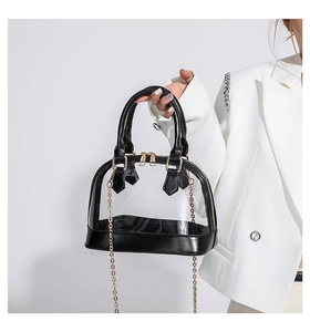 Detail of transparent PVC shell bag with black faux leather trim and gold chain strap