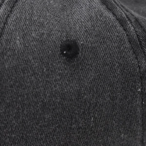 Macro detail of the embroidered eyelet and washed cotton twill fabric on the baseball cap