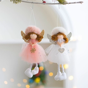 Close-up of plush Christmas angel dolls with lace skirts hanging on pine branches