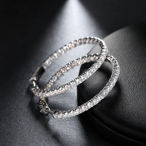 Elegant silver hoop earrings with full pavé cubic zirconia on black leather background