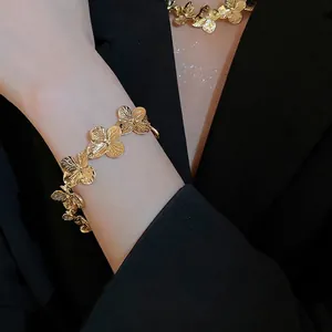 Elegant gold floral necklace and bracelet set with brushed metal texture on a model