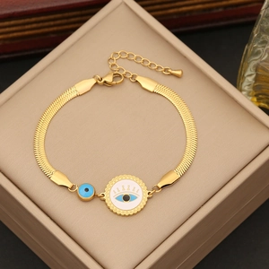 Detail of gold evil eye charm bracelet with snake chain on a jewelry display box