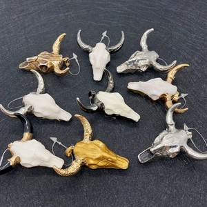 Detailed view of nine mixed color bull skull pendants with clear resin connectors for DIY