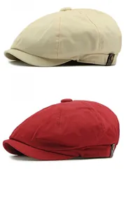Detail of beige and wine red newsboy caps featuring vintage leather straps and bronze buttons