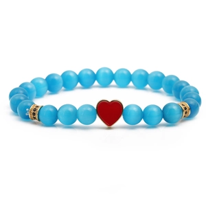 Natural stone bracelet with blue cat eye beads and a gold-edged red heart charm
