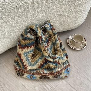 Detail of vintage geometric knit plush tote bag featuring soft fleece textures and lining