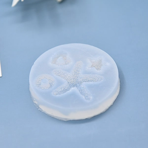 Close-up of light blue silicone mold featuring detailed starfish, seashell, and heart shapes