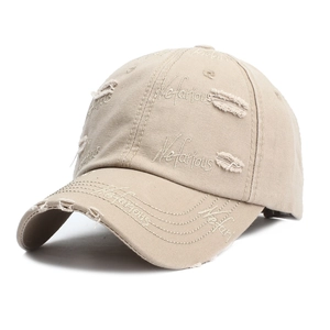 Detailed view of beige baseball cap with distressed holes and Nefarious embroidery