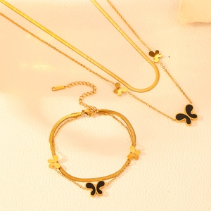 Close-up of gold stainless steel double-layered necklace and bracelet set with butterfly