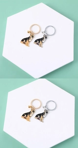 Detail view of German Shepherd keychains in gold and silver finish with small bells