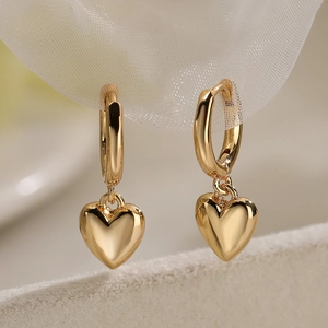 Elegant gold heart pendant hoop earrings with zircon on soft white mesh background