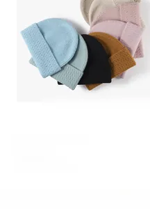 Flat lay of ribbed knit beanies showing light blue, mint, yellow, and pink color options