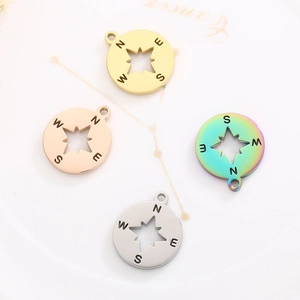 Detail of round compass pendants in four colors with hollow eight-pointed star design