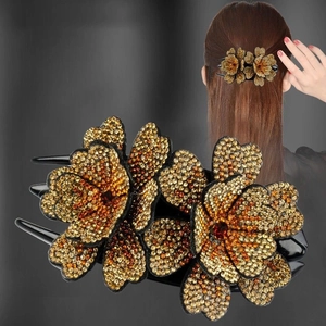 Pince à cheveux noire élégante avec fleurs en strass ambrés et vue sur modèle