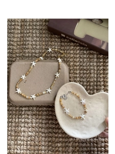 Starfish beaded necklace and bracelet set displayed on a professional jewelry stand